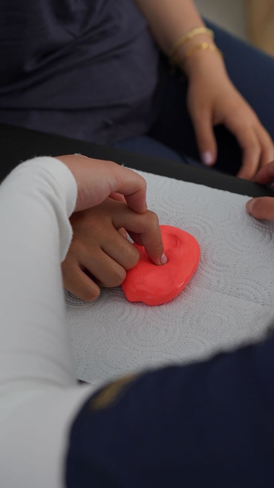Travail de la main sur pâte de rééducation, geste guidé par la praticienne.